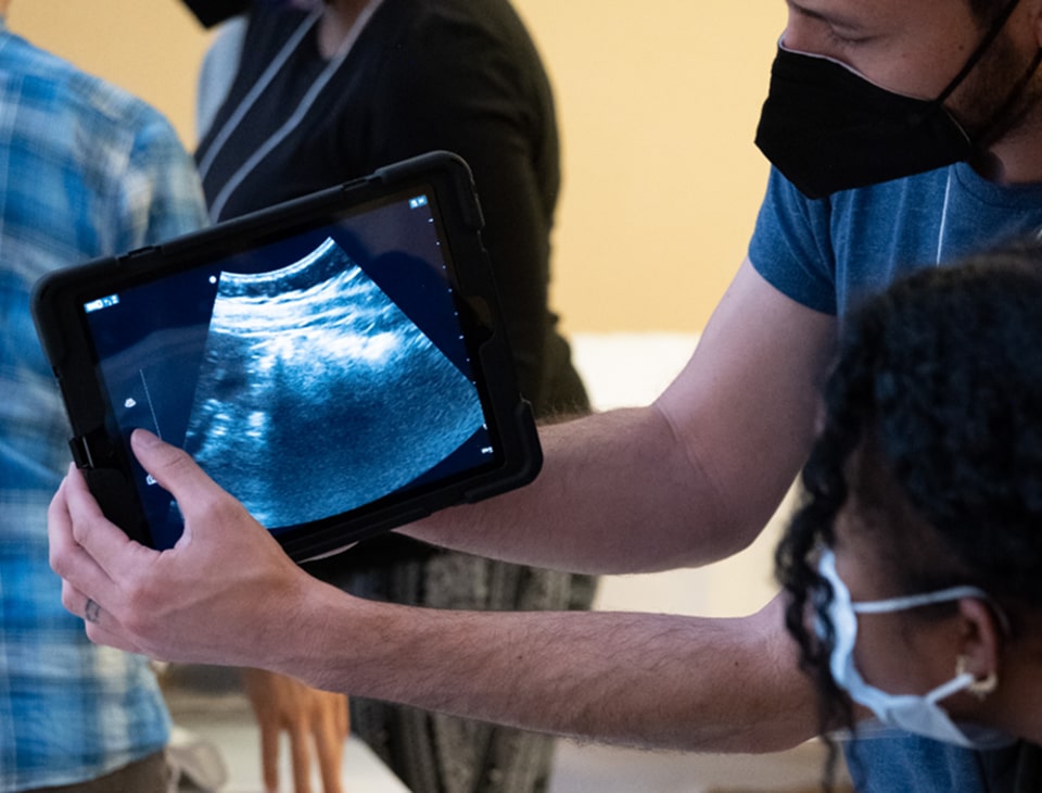 A man operates an ultrasound device while a woman observes the screen intently, showcasing a medical examination.